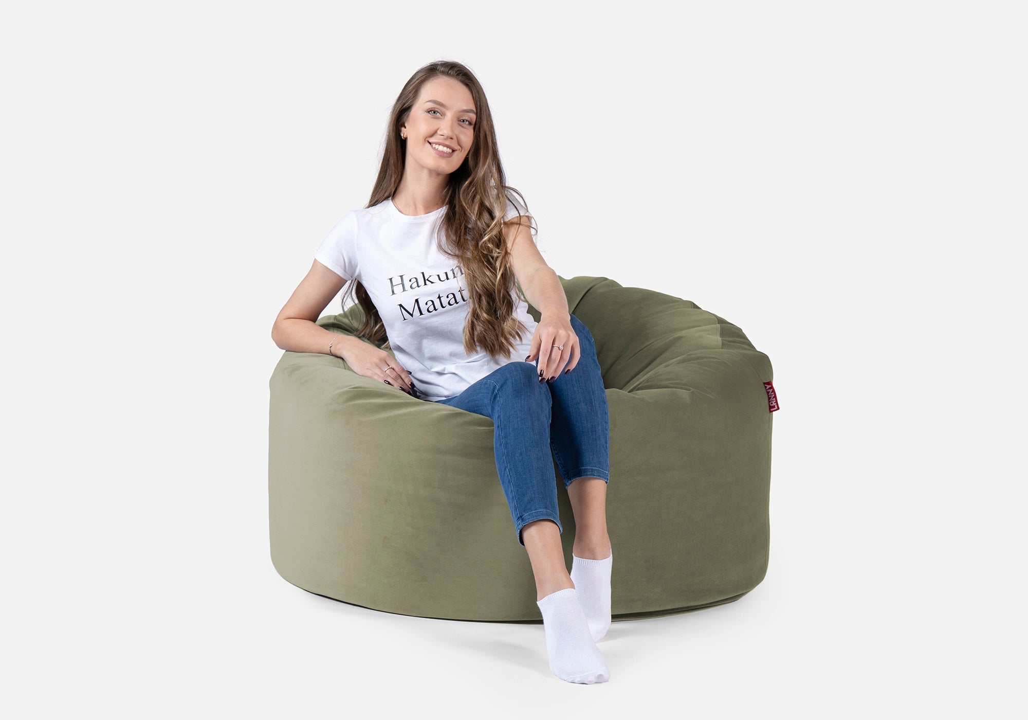 Woman sitting on a Lanny Original medium green bean bag chair with a white background