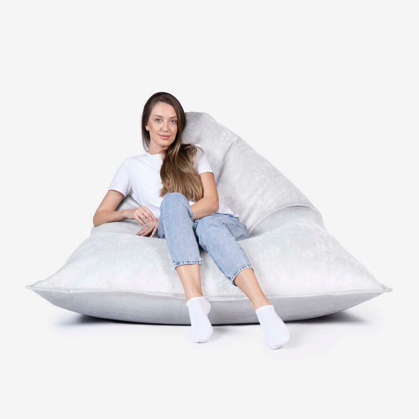 Woman sitting on a Lanny Sloppy large bean bag chair against a white background