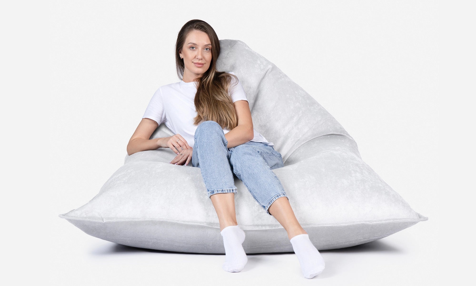 Woman sitting on a Lanny Sloppy large bean bag chair against a white background