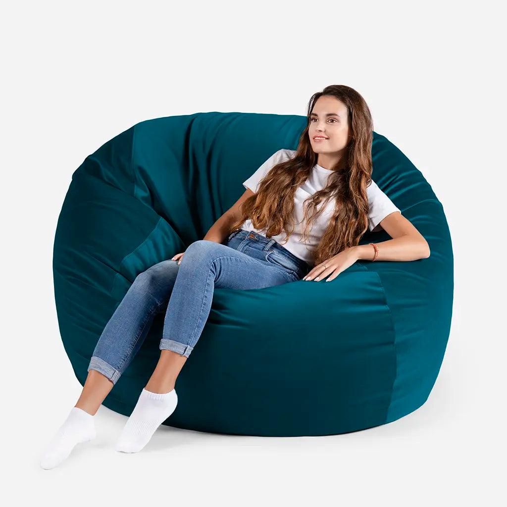 Woman sitting comfortably on a Lanny Sphere oversized velvet bean bag chair in Aqua Blue color for UAE living room seating