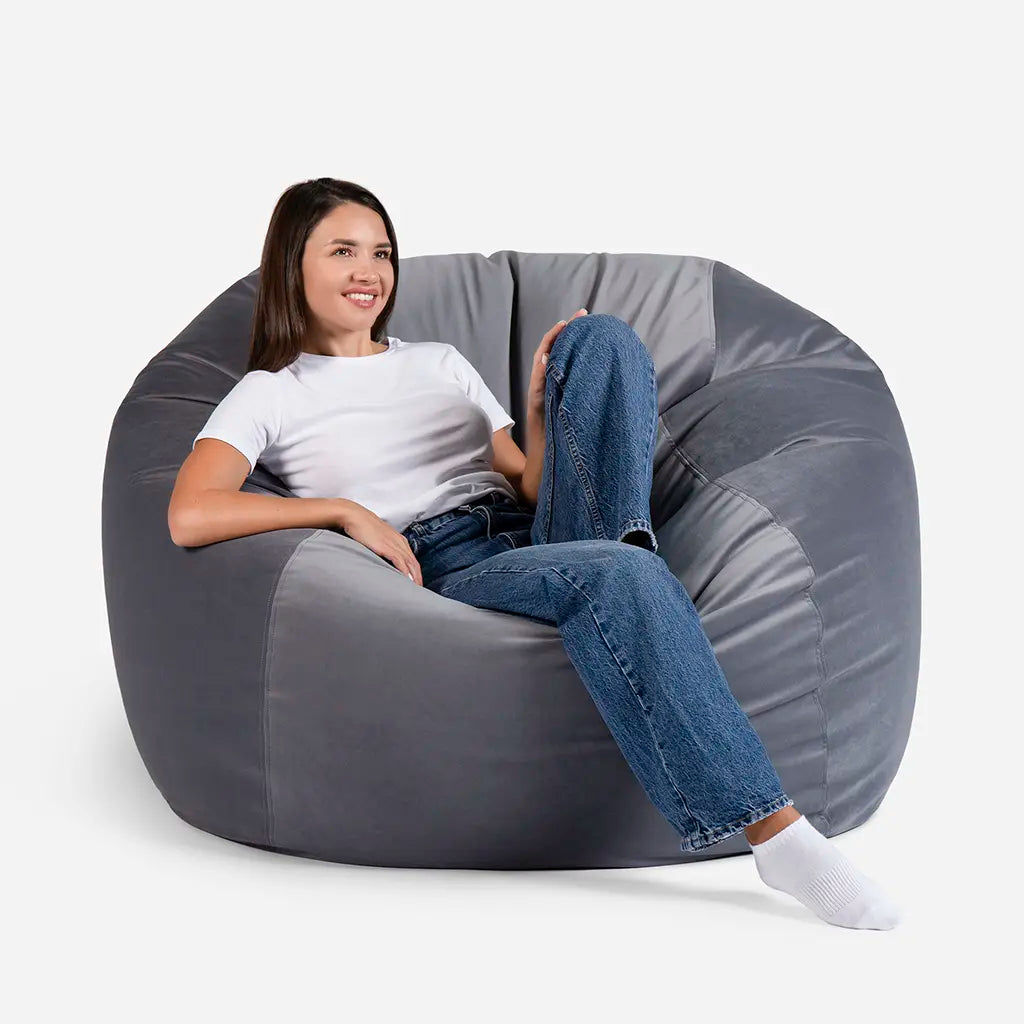 Woman sitting comfortably on a Lanny Sphere oversized velvet bean bag chair in Gray color for UAE living room seating