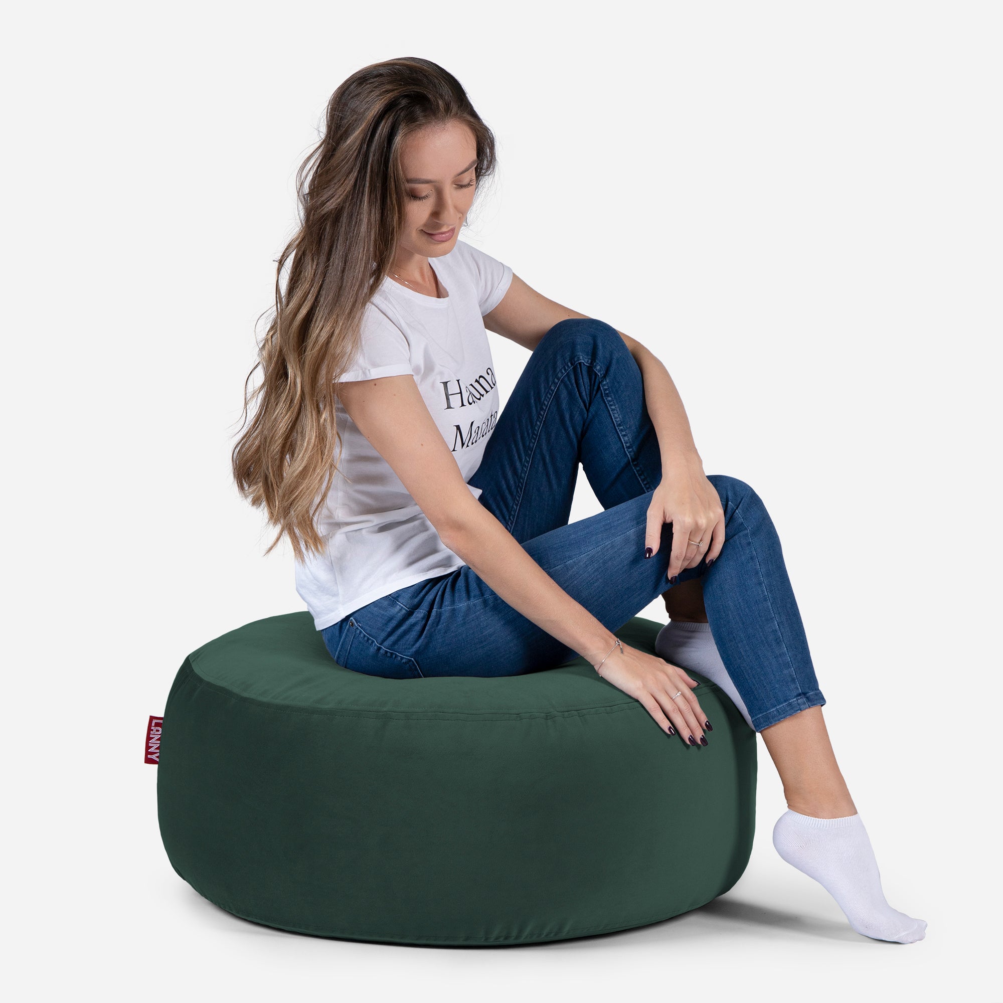 girl siting on Lanny pouf made from velvet fabric in Green color