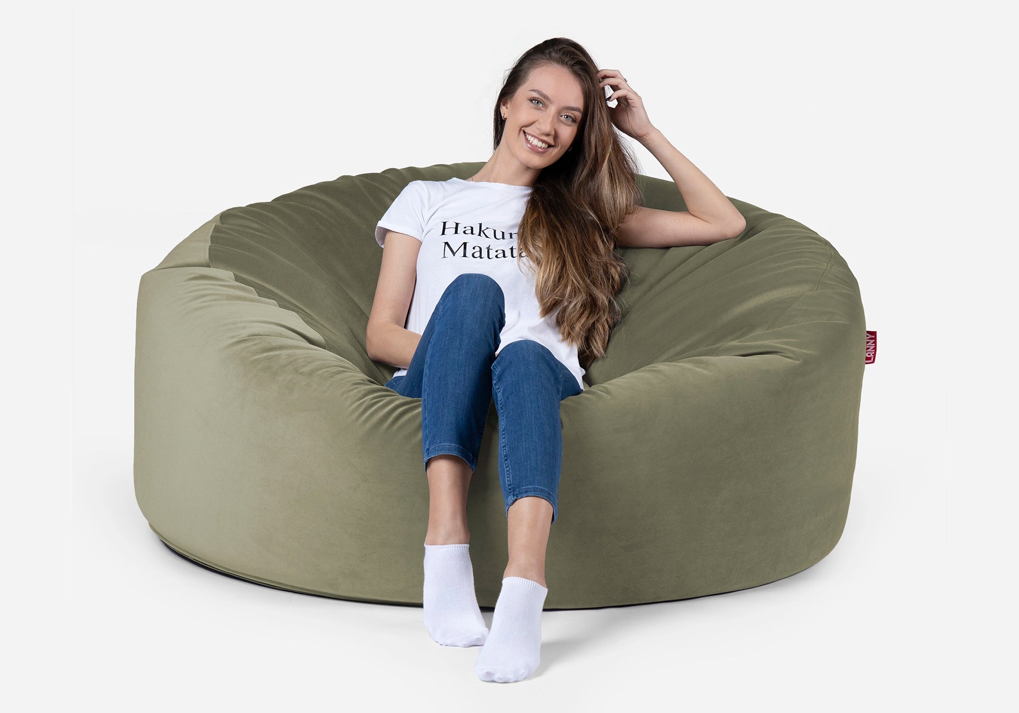 Woman sitting on a Lanny Original  large green bean bag chair with a plain background