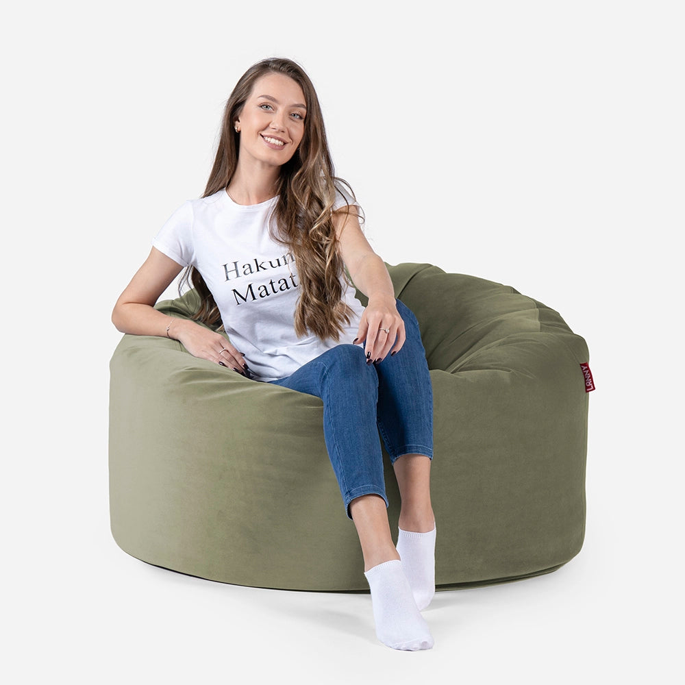 Woman sitting on a Lanny Original Medium green bean bag chair with a white background