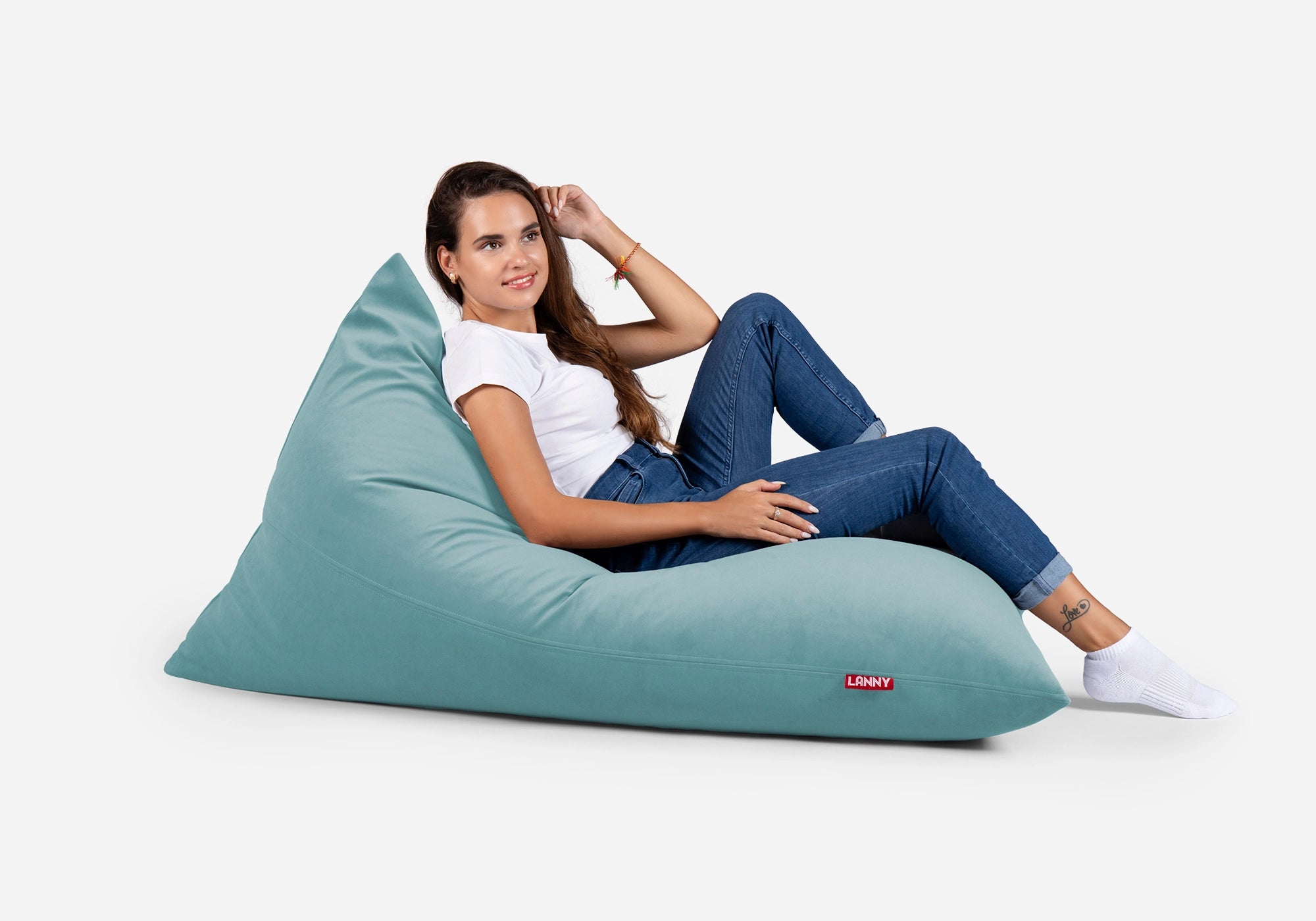 Woman sitting on a Lanny teal bean bag chair with a white background