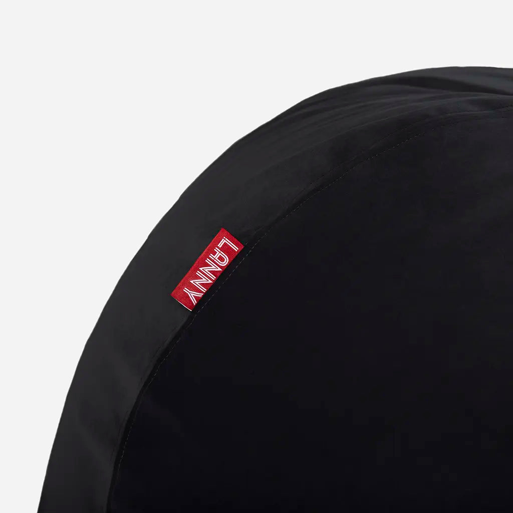 Close-up detail of the Lanny red brand tag and the ultra-soft texture of the black velvet bean bag fabric