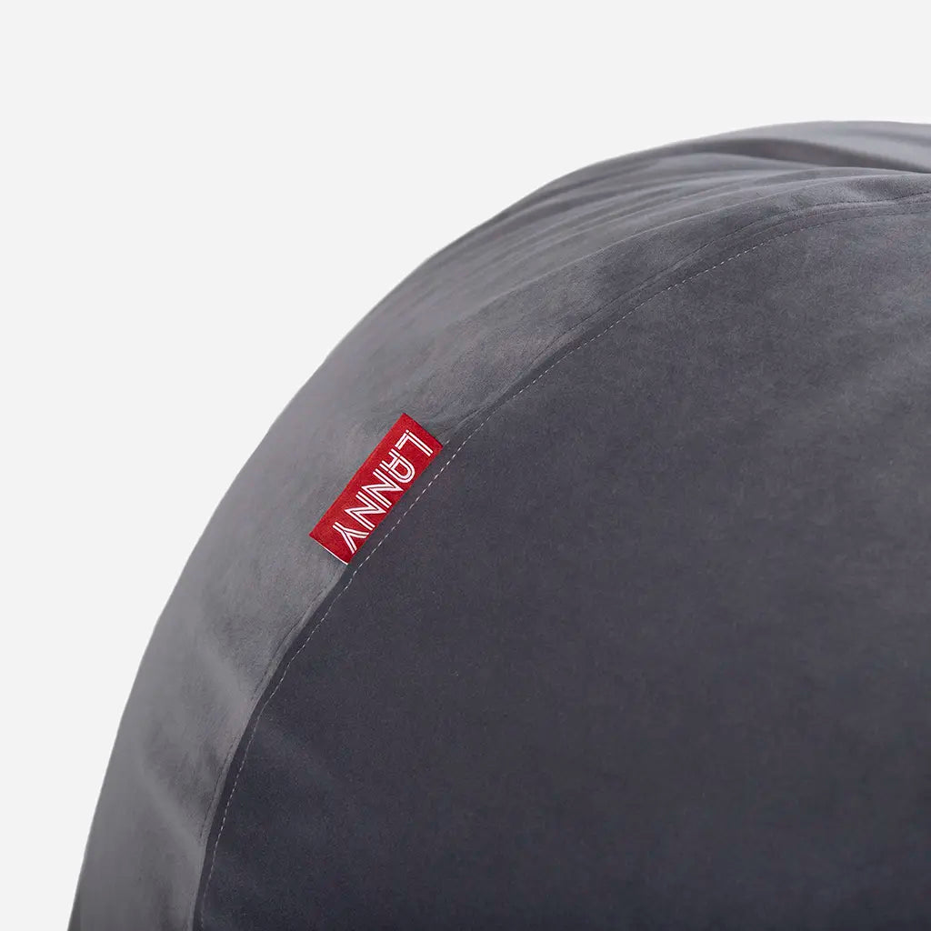 Close-up detail of the Lanny red brand tag and the ultra-soft texture of the gray velvet bean bag fabric