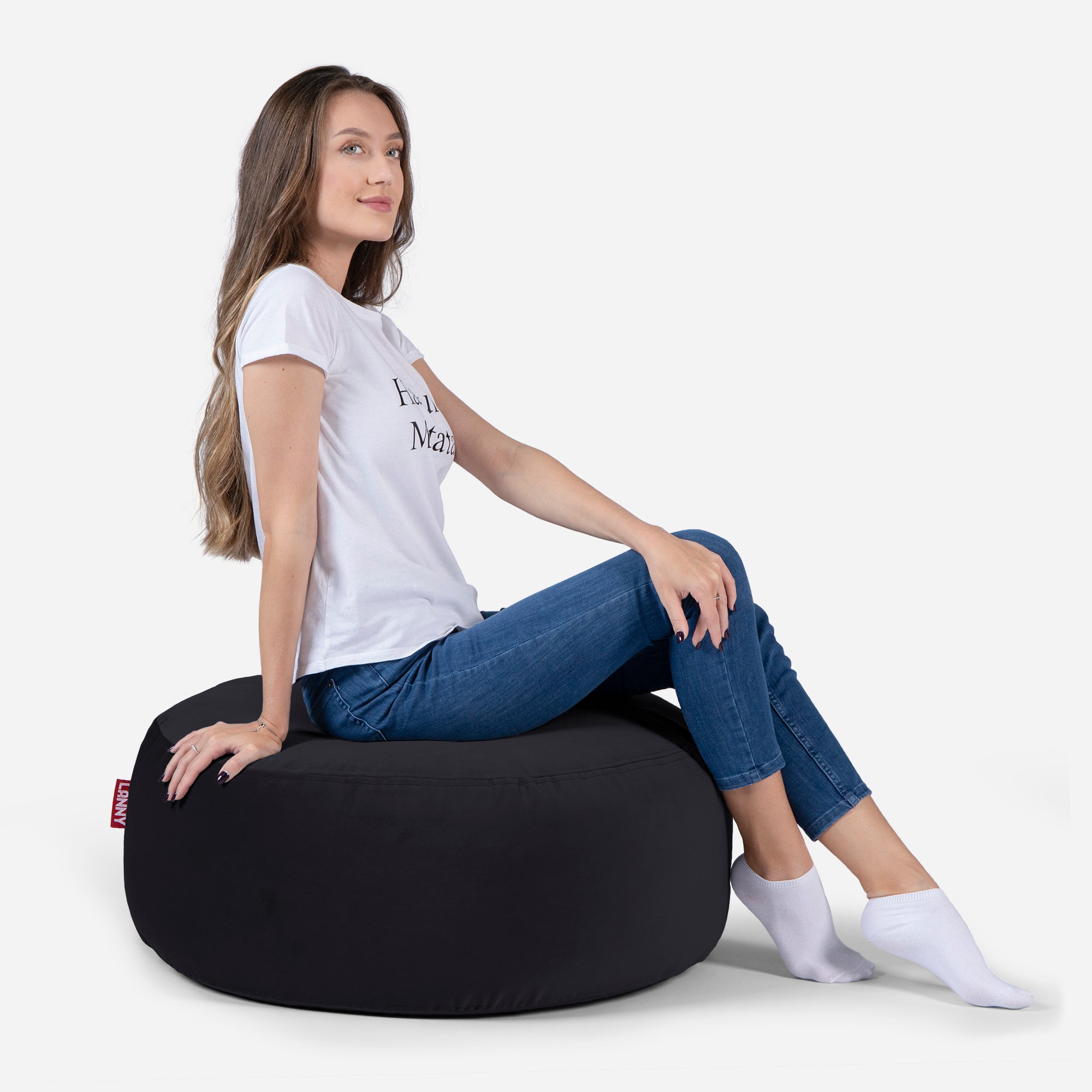 girl siting on Lanny pouf made from velvet fabric in Black color