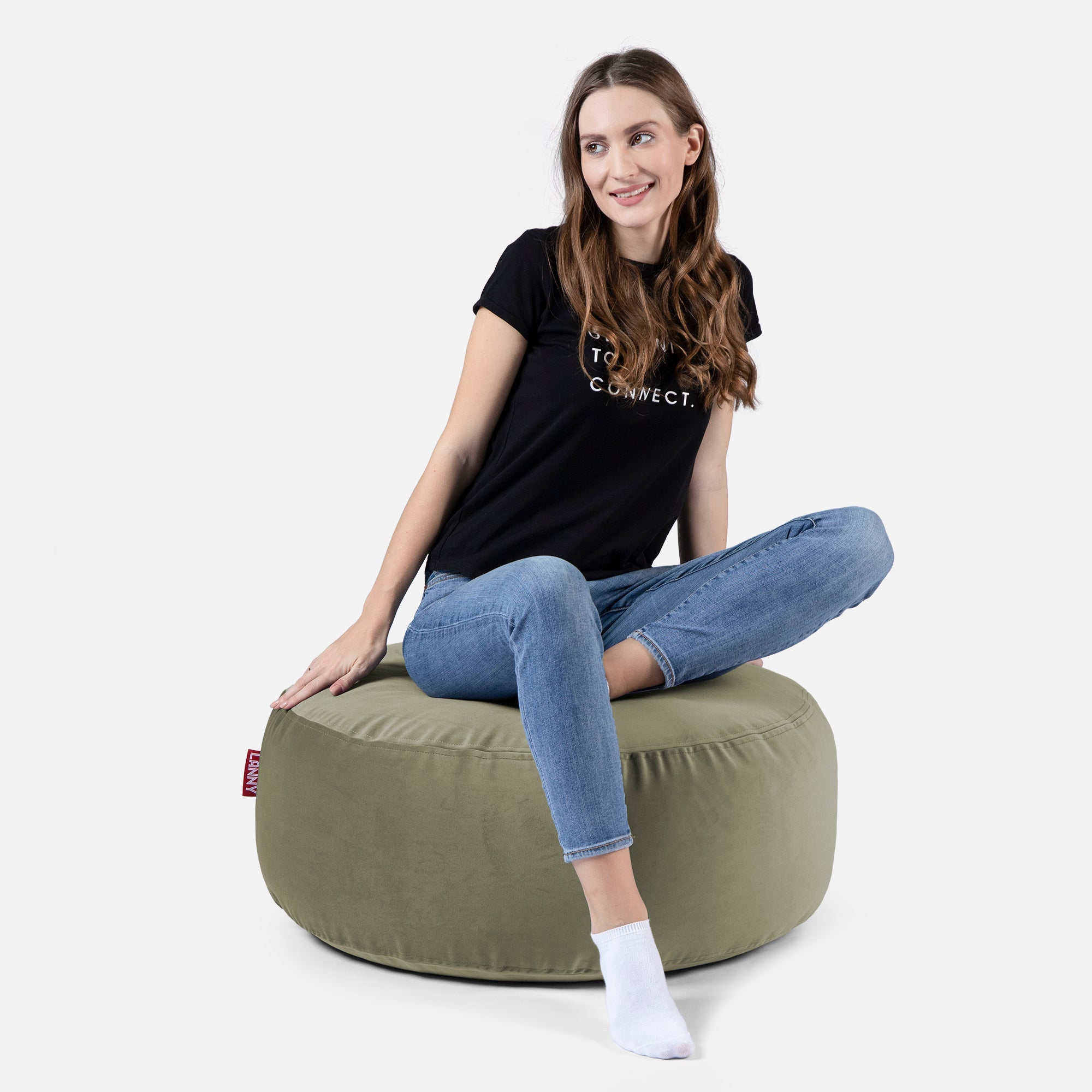 girl siting on Lanny pouf made from velvet fabric in Khaki color
