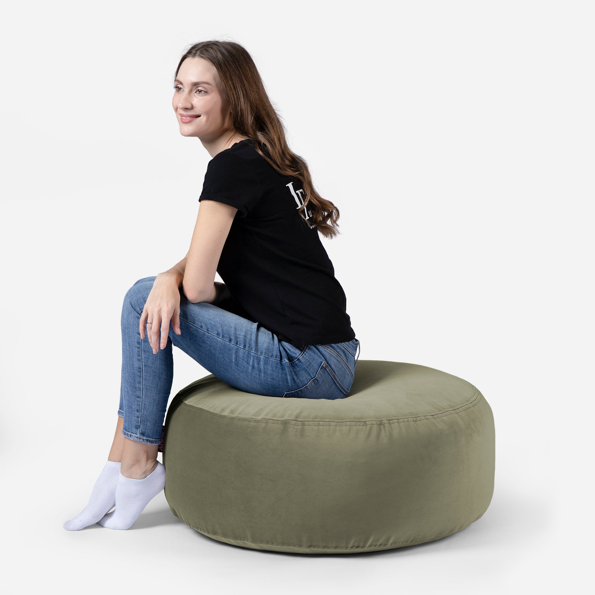 girl siting on Lanny pouf made from velvet fabric in Khaki color