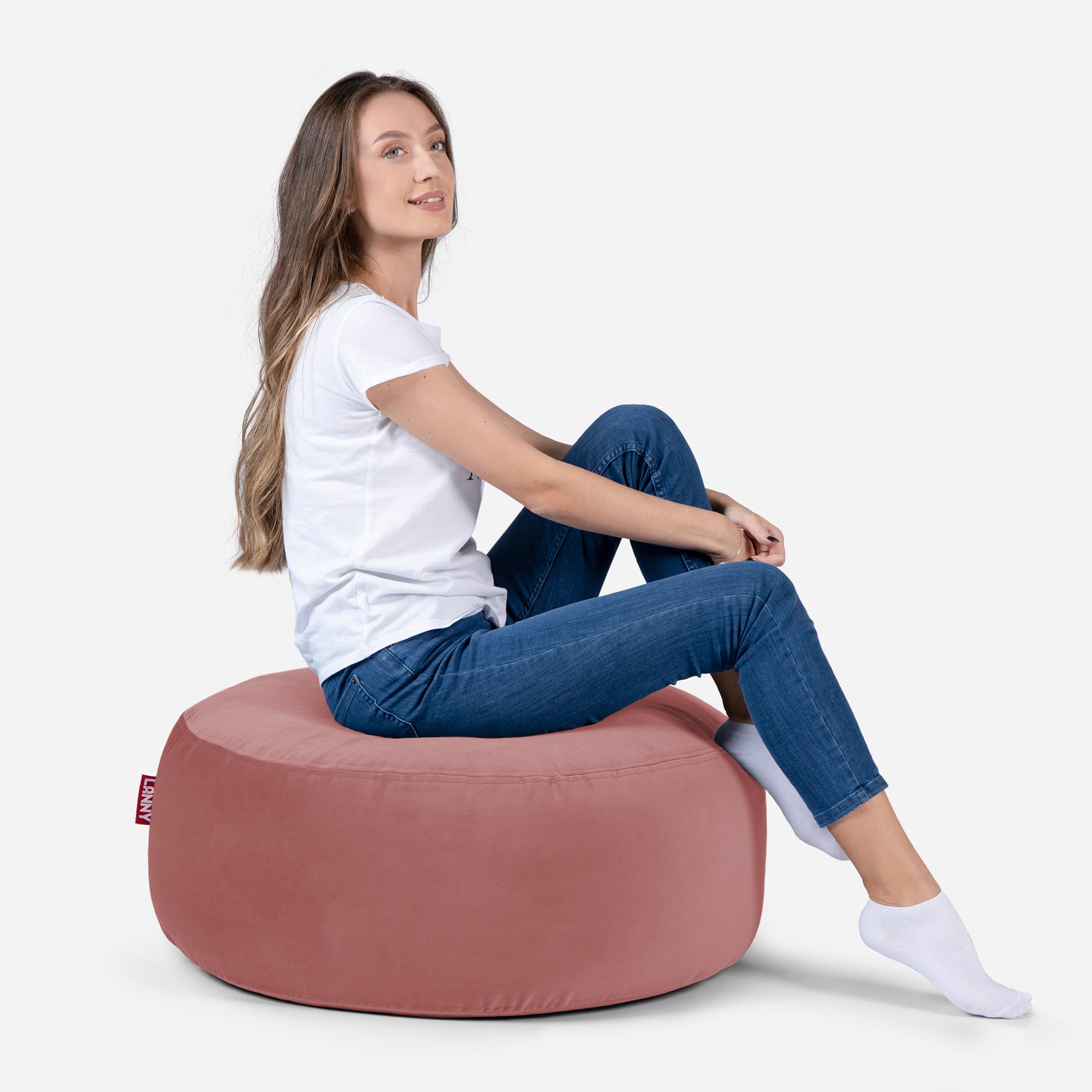 girl siting on Lanny pouf made from velvet fabric in Pink color